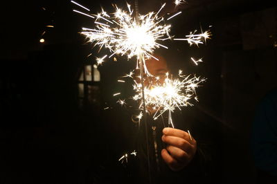 Man with lit sparklers at night