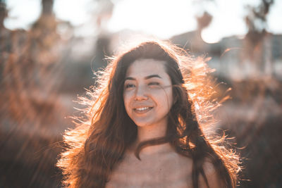 Close-up portrait of shirtless woman during sunset