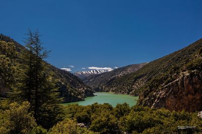 Scenic view of mountains against clear blue sky