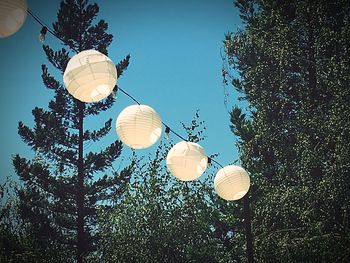 Low angle view of lanterns hanging against sky