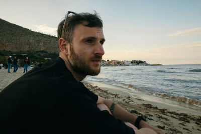 Portrait of man on beach against sky