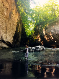 Woman nearly rock in the mountain river 