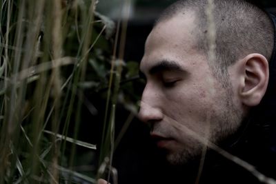 Close-up of man sitting by plants