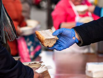 Midsection of people holding ice cream at market