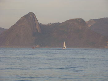 Scenic view of sea and mountains against sky