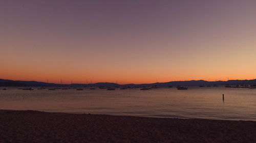 Scenic view of beach against clear sky during sunset
