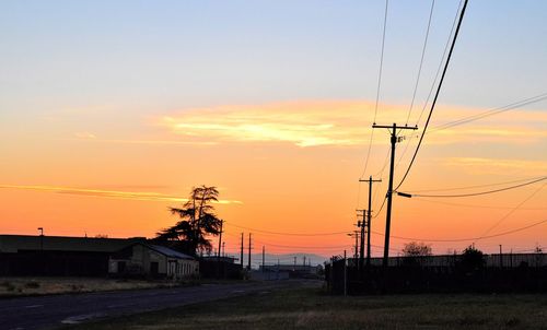 Silhouette electricity pylon against sky during sunset