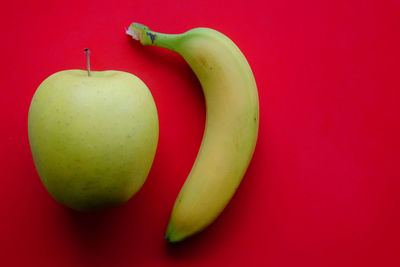 Close-up of apple against red background