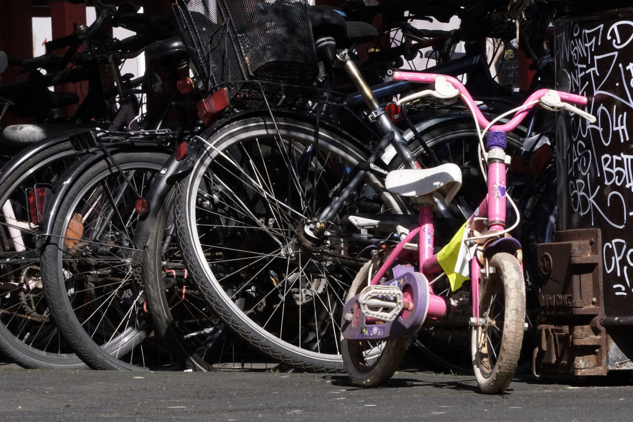 CLOSE-UP OF BICYCLES PARKED ON STREET