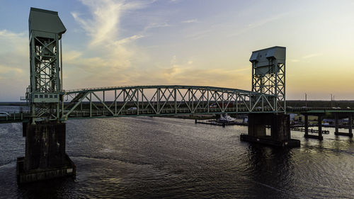 Bridge over river against sky during sunset