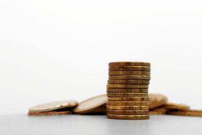 Close-up of coins on table against white background