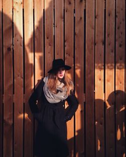 Girl looking away while standing against wall