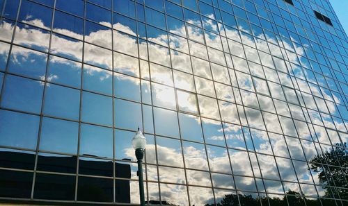 Low angle view of modern building against cloudy sky