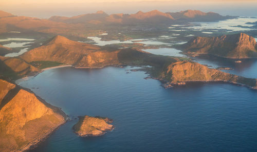 High angle view of sea by mountain against sky