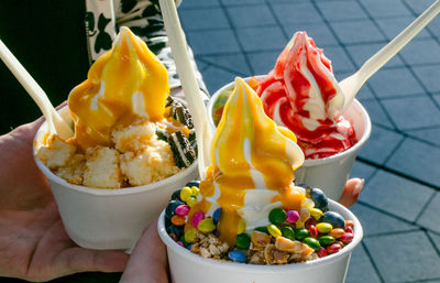 Cropped hands holding ice cream bowls