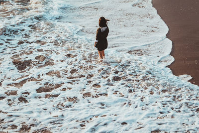 Female standing in waves on a beach in santa monica california. 