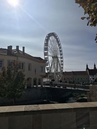 Ferris wheel by buildings against sky