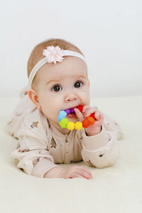 Portrait of cute baby girl with toy on white background