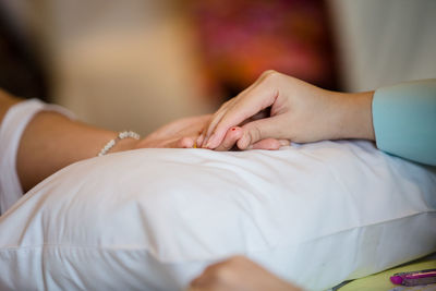 Close-up of woman lying on hand