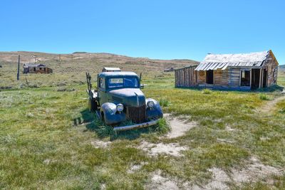 Abandoned truck on field against sky