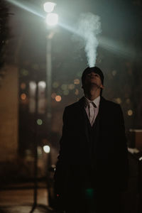 Young man smoking at night