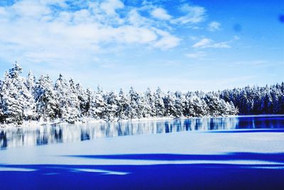 Scenic view of frozen lake against blue sky