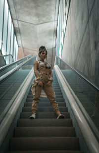 Low angle view of woman on escalator in building