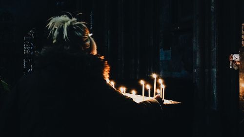 Rear view of woman looking at illuminated fire at night