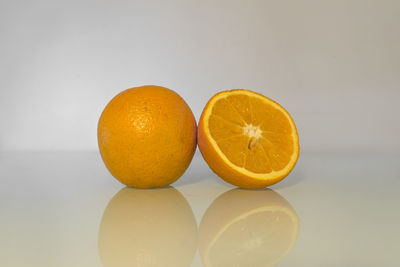 Close-up of orange on table against white background
