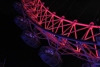 Low angle view of illuminated ferris wheel against sky at night