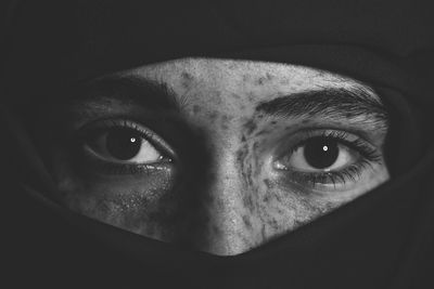 Portrait of young woman against black background