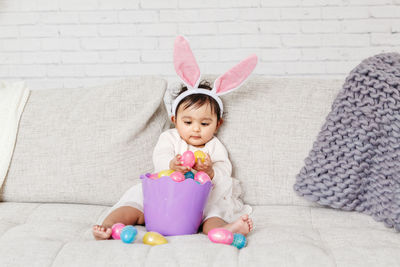 Cute girl playing with easter eggs at home