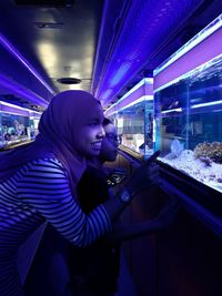 Side view of girl looking at illuminated glass