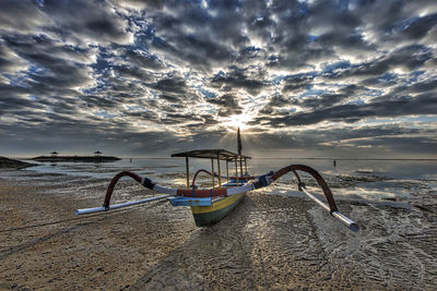 View of empty beach against cloudy sky