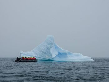 Scenic view of icebergs in sea against clear sky