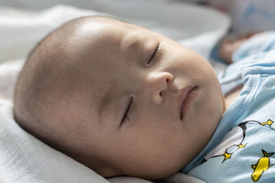 Close-up of baby sleeping on bed