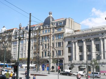 People on street against buildings in city