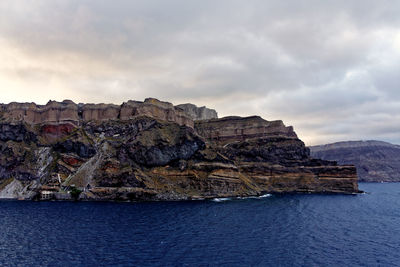 Rock formations by sea against sky