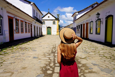 Back view of young tourist woman in the historic town of paraty, brazil