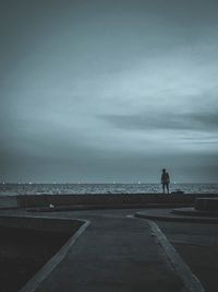 Rear view of man on beach against sky