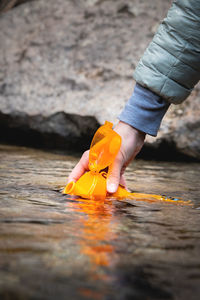 Close-up of female hands pouring drinking water from a mountain spring into a silicone bottle