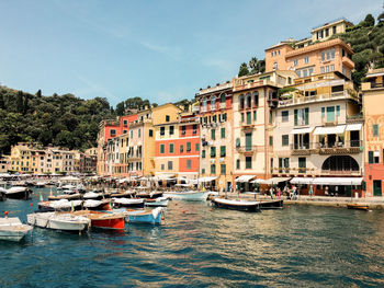 Boats moored in canal by buildings in city