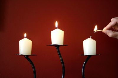 Close-up of illuminated candles against colored background