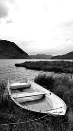 Boats moored on lake against sky