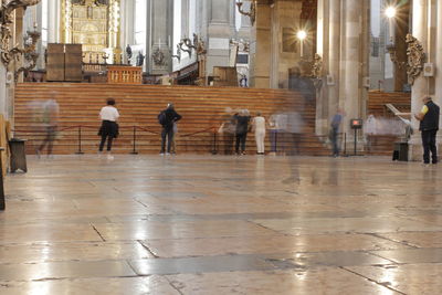 People walking on wet floor in city