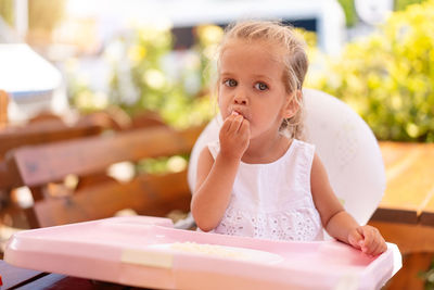 Portrait of cute girl sitting on table