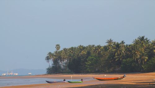 Boats moored on sea against clear sky