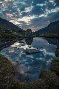 Scenic view of lake by mountains against sky