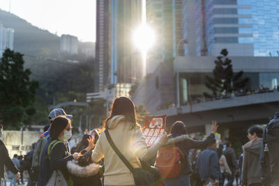 People on street against buildings in city