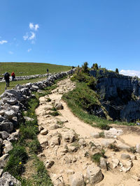 People walking on land against sky